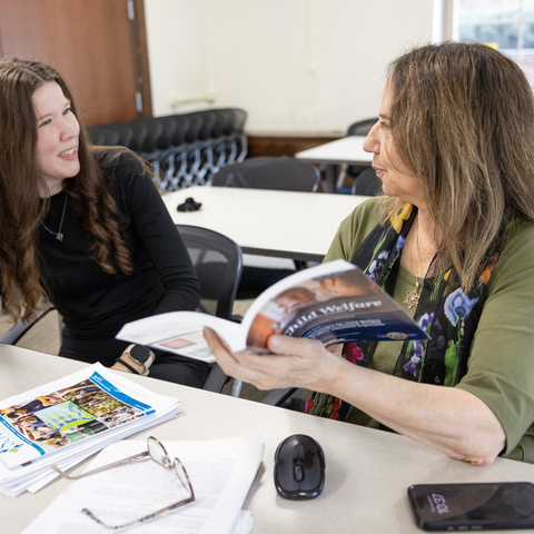 Miriam Landsman and a woman looking at a book